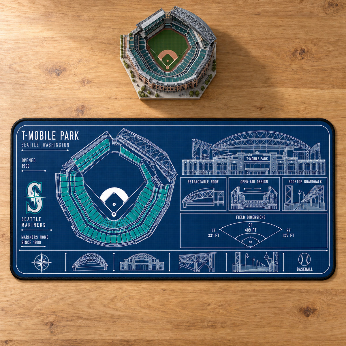 Seattle Mariners T-Mobile Park blueprint desk mat, 16" x 32", on a wooden desk with a decorative stadium model