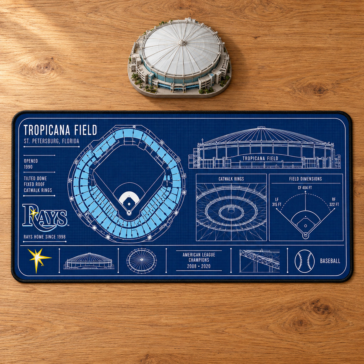 Tampa Bay Rays Tropicana Field blueprint desk mat, 16" x 32", on a wooden desk with a decorative stadium model